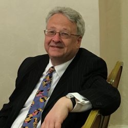 photo of a man in a business suit, sitting on a chair